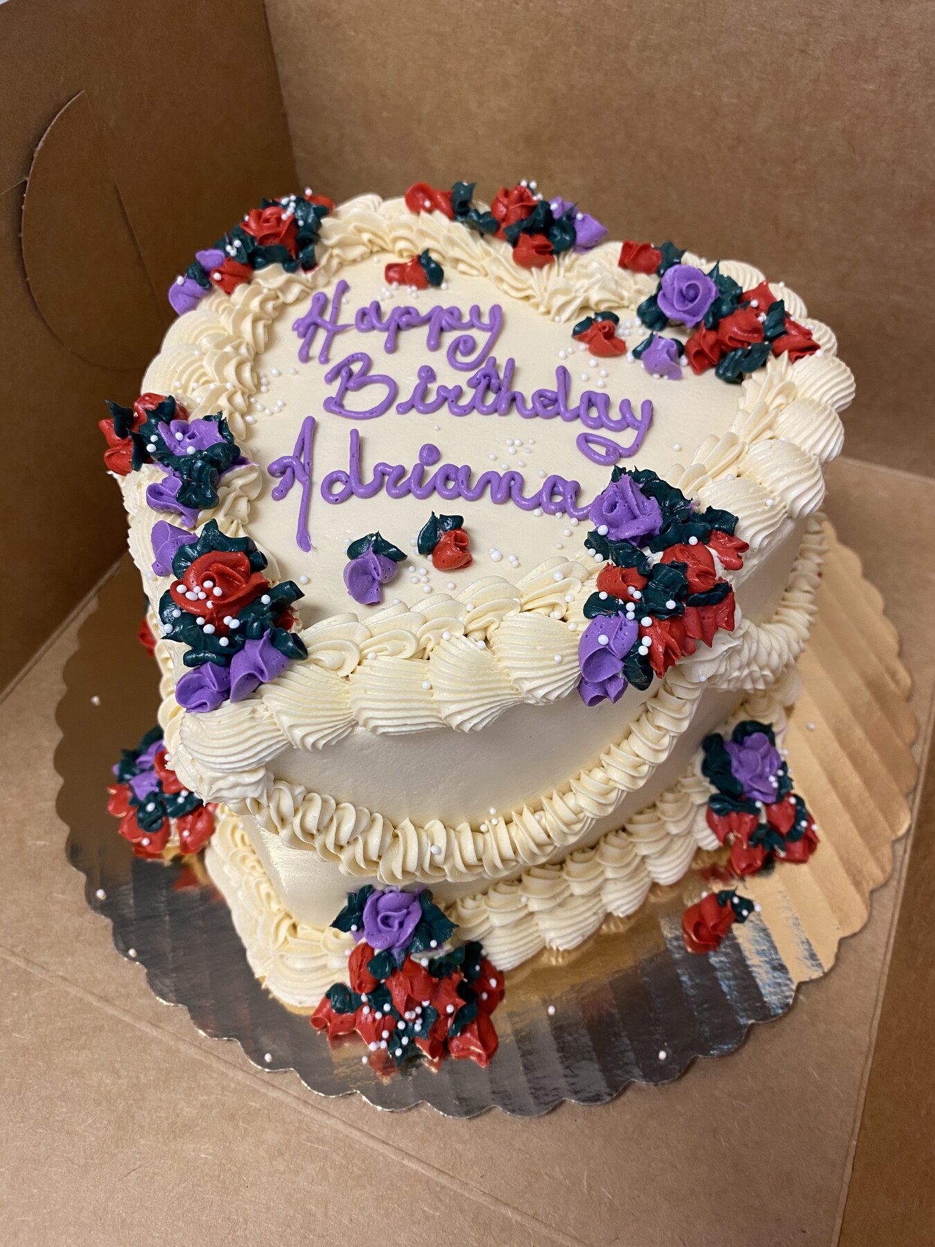 Heart-shaped buttercream birthday cake with piped roses and script lettering