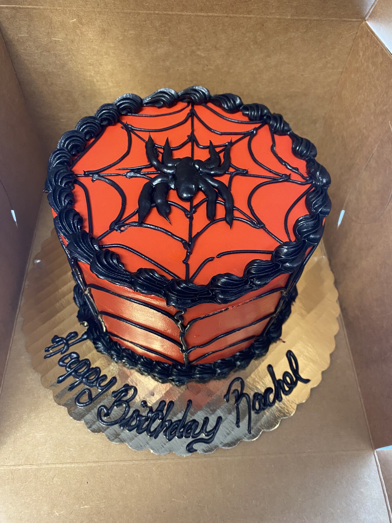 Orange and black spider web birthday cake with piped border