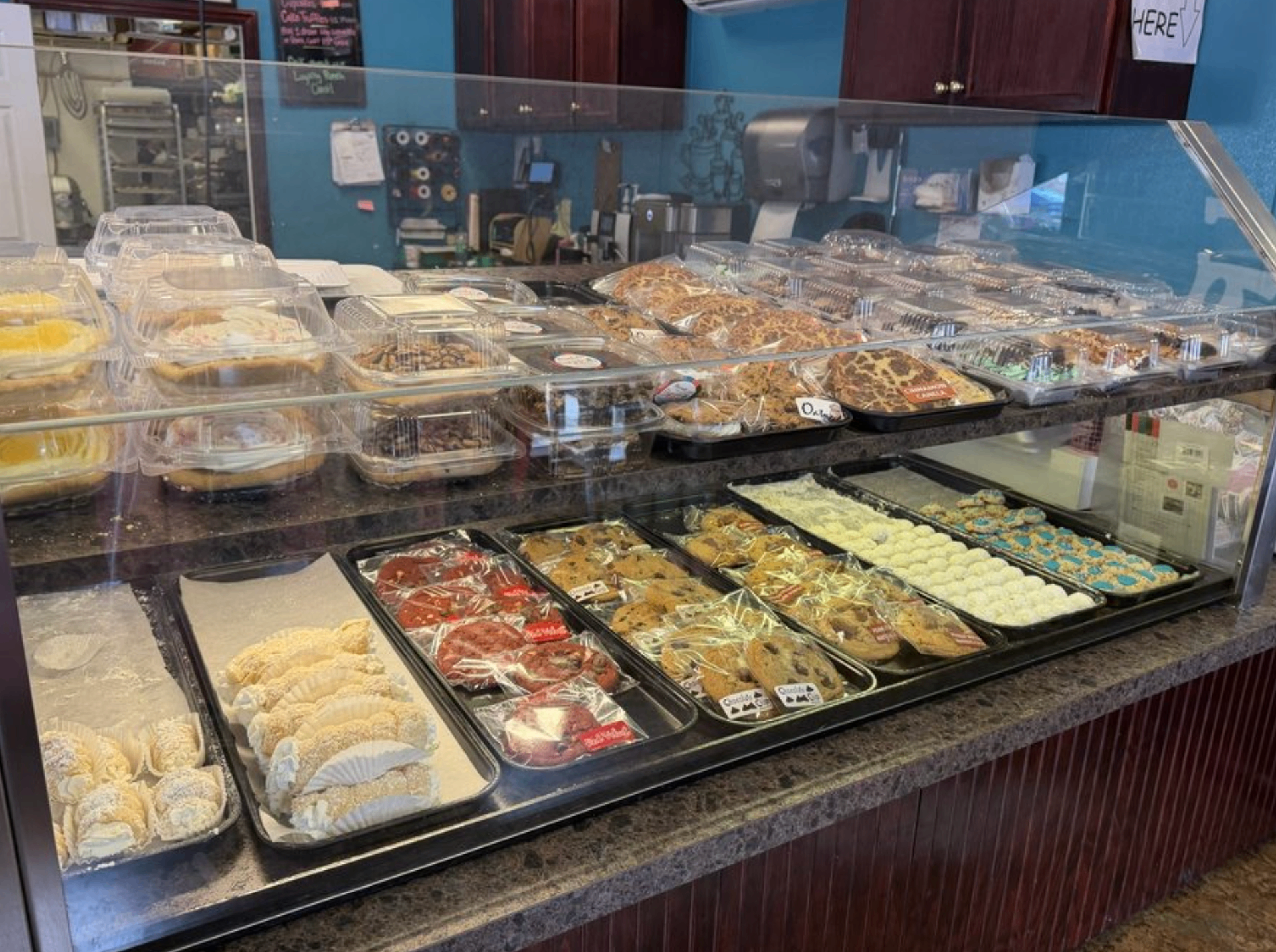 Bakery display case filled with cannoli, cookies, pies, and fresh baked goods